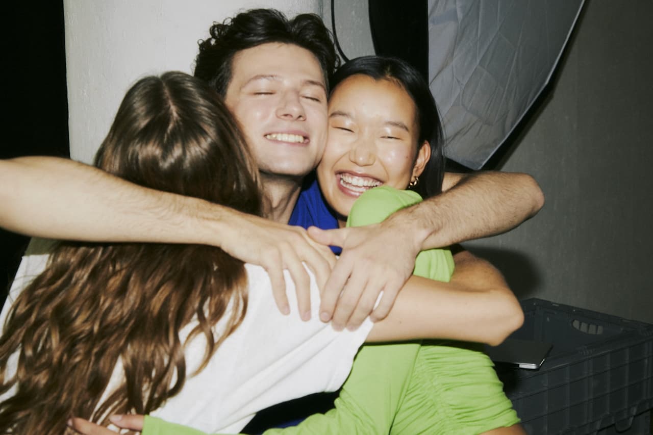 Young people hugging each other smiling